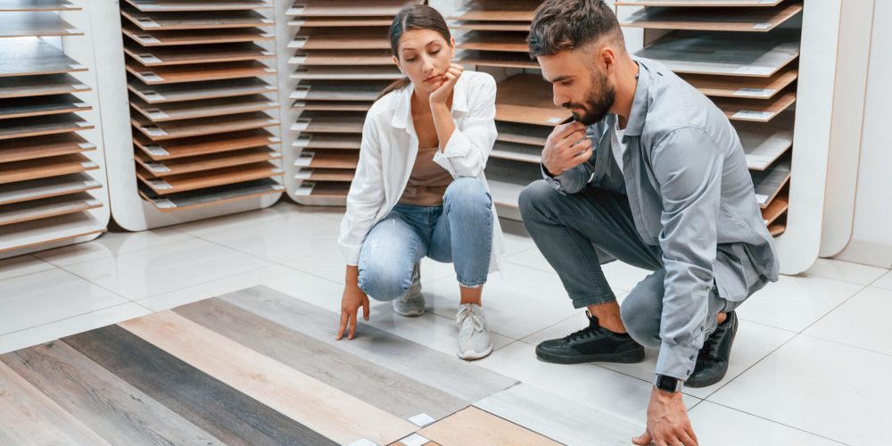 Choosing parquet. Woman and man is in the store of goods for the home.