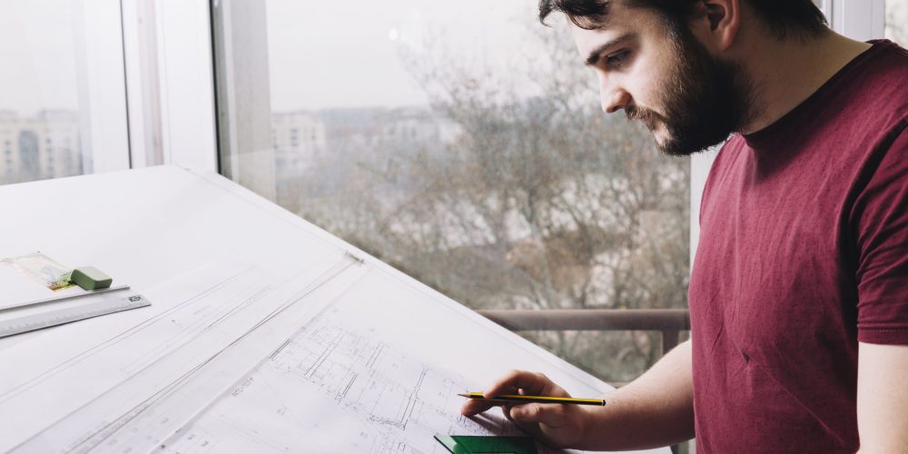 side-view-architect-drawing-blueprints